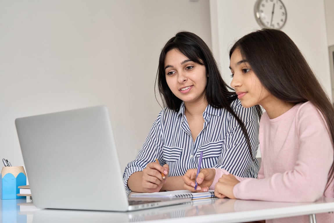 Mother Helping Teen School Daughter Studying Online Class 