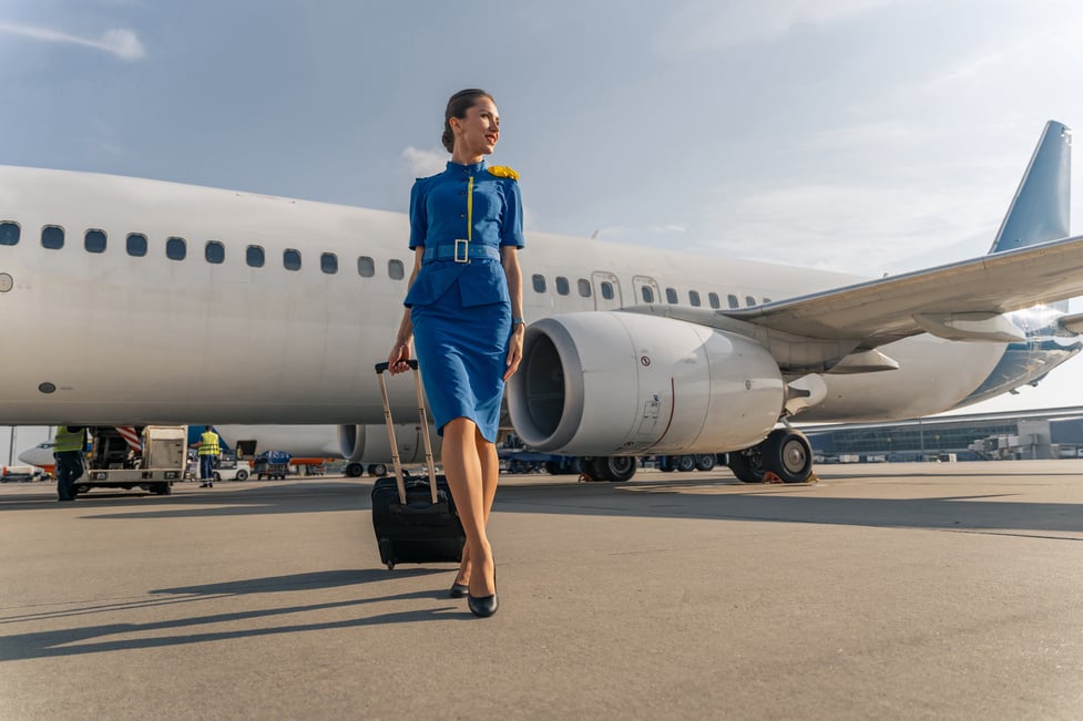 Female Flight Attendant Walking with Black Suitcase